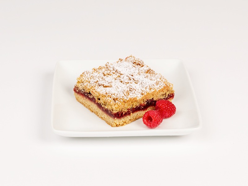 A raspberry crumble bar with fresh raspberries