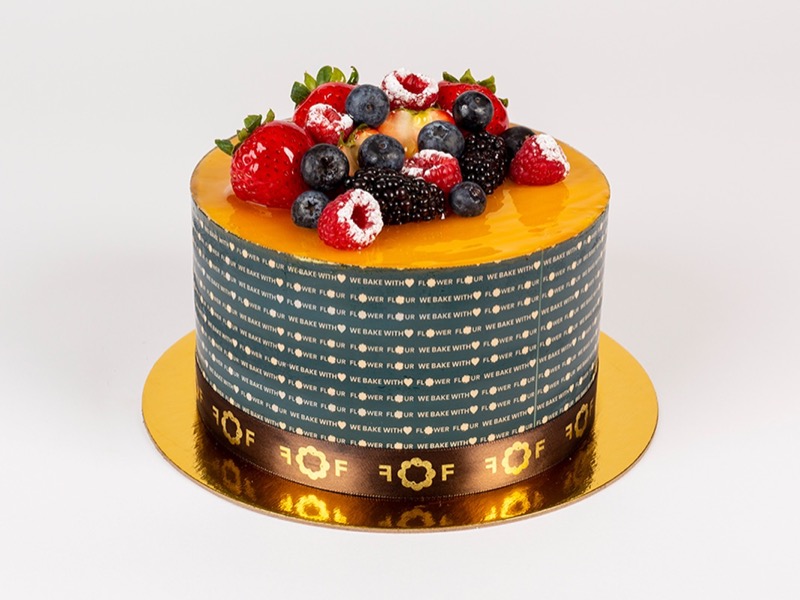 Mango tango cake with a golden mango top and fresh berries