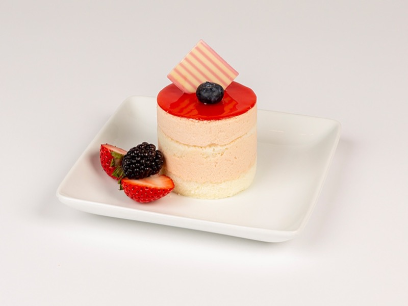 Individual guava dessert with a pink top and a raspberry