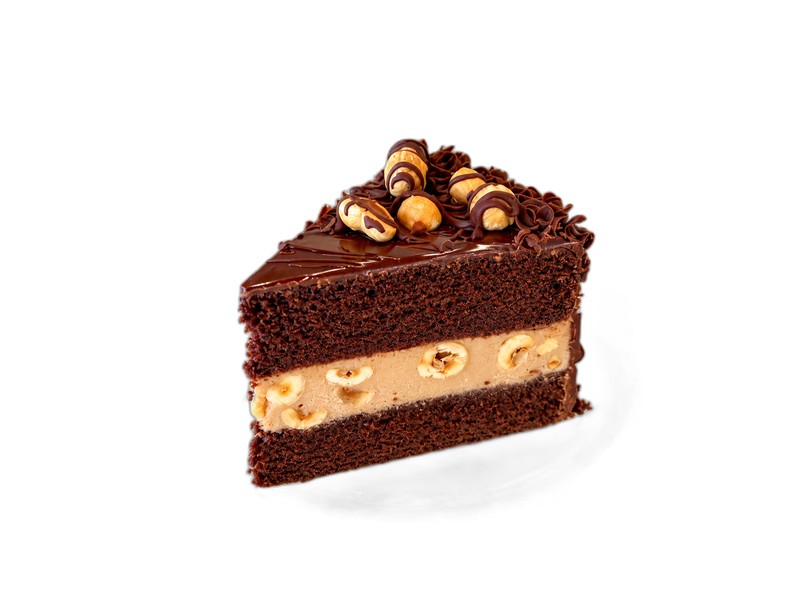 A slice of chocolate hazelnut cake with hazelnut cream, whole hazelnuts, and chocolate curls on a glass plate
