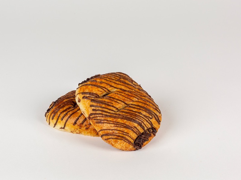 A chocolate croissant striped with chocolate