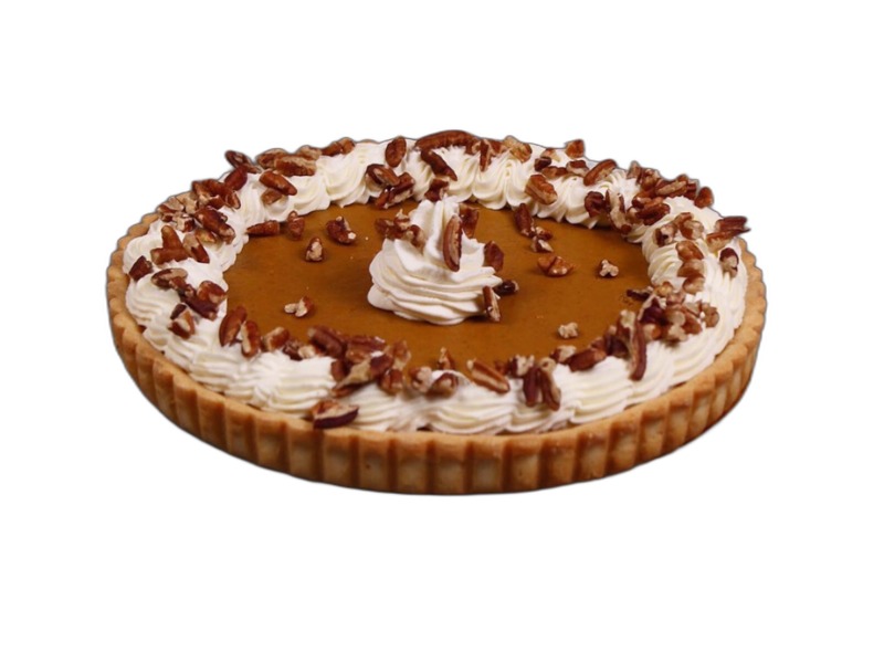 Whole pumpkin pie with whipped cream rosettes and chopped pecans on a fluted crust