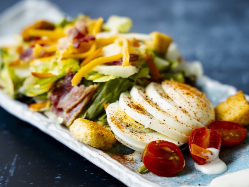 A club salad with sliced egg and bacon