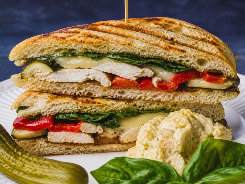 Pressed grilled chicken panini with Swiss, roasted peppers, zucchini, and spinach