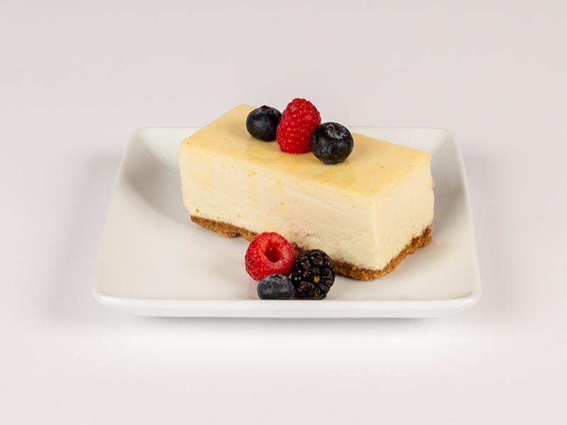 A slice of New York cheesecake with fresh berries
